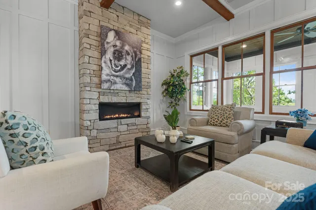 a living room with furniture a fireplace and a floor to ceiling window
