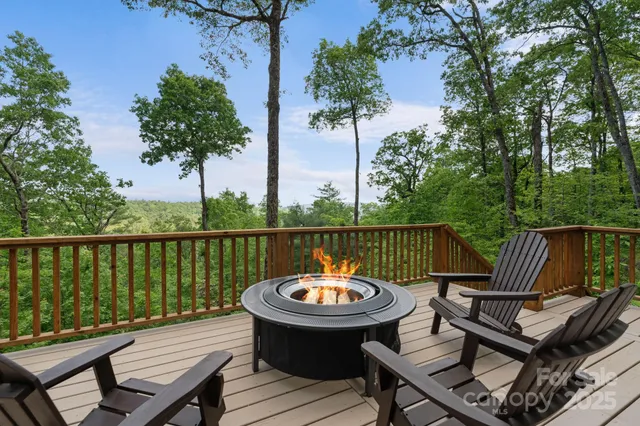 a view of a roof deck with table and chairs with wooden floor and fence