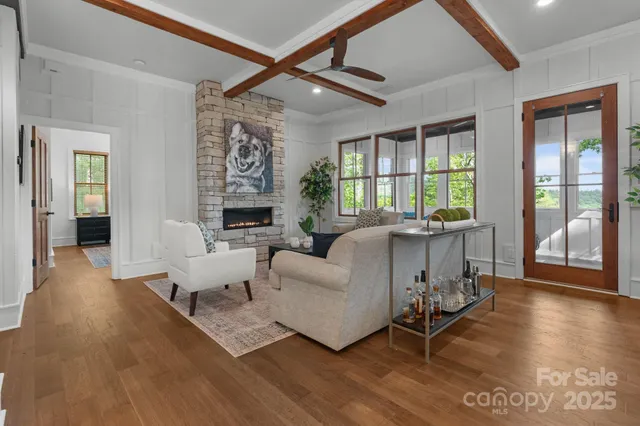 a living room with furniture large window and wooden floor