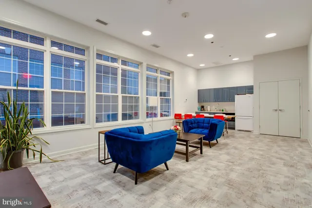 a living room with furniture and kitchen area