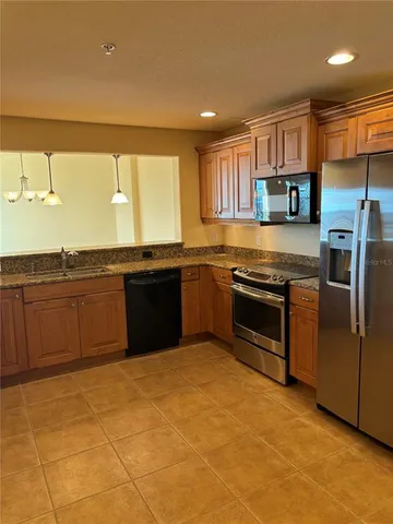 a kitchen with a sink a refrigerator and a stove top oven