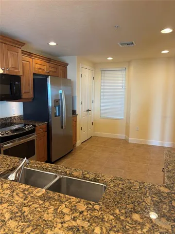 a view of an empty room with a kitchen