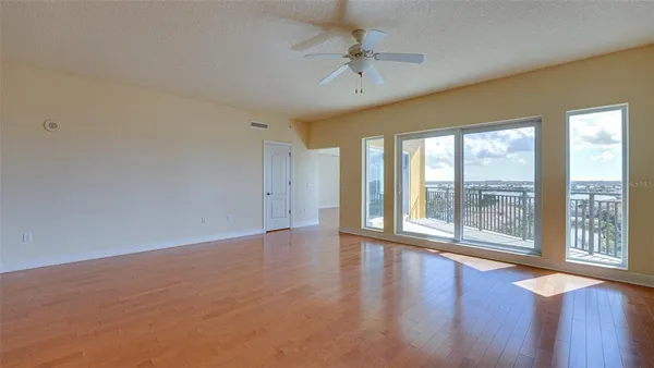 an empty room with fan and windows