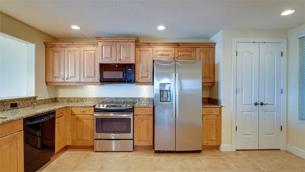 a kitchen with granite countertop a sink stove and cabinets