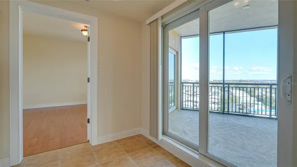 a view of a hallway with a glass door and a bathroom