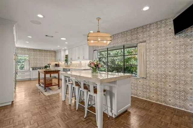 a kitchen with stainless steel appliances granite countertop a stove and a wooden floor
