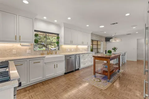 a kitchen with kitchen island white cabinets and chairs