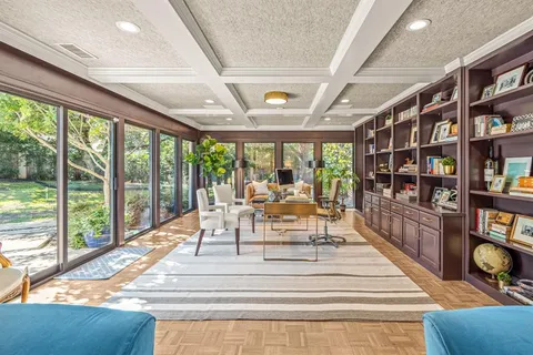 a view of living room with furniture book shelf and a floor to ceiling window