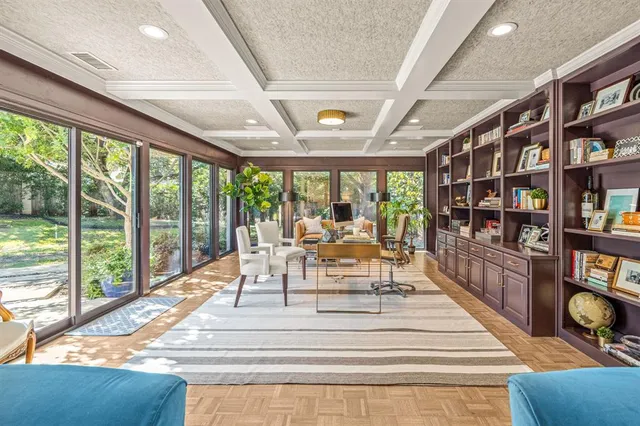 a view of living room with furniture book shelf and a floor to ceiling window