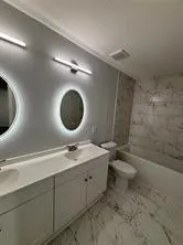 a bathroom with a toilet a sink and mirror