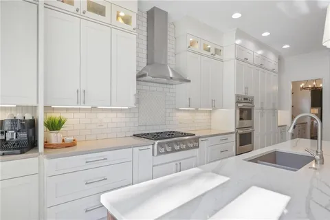 a kitchen with stainless steel appliances kitchen island granite countertop a sink a stove and a refrigerator