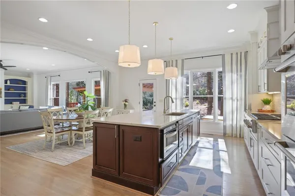a kitchen with kitchen island granite countertop a sink and a stove top oven