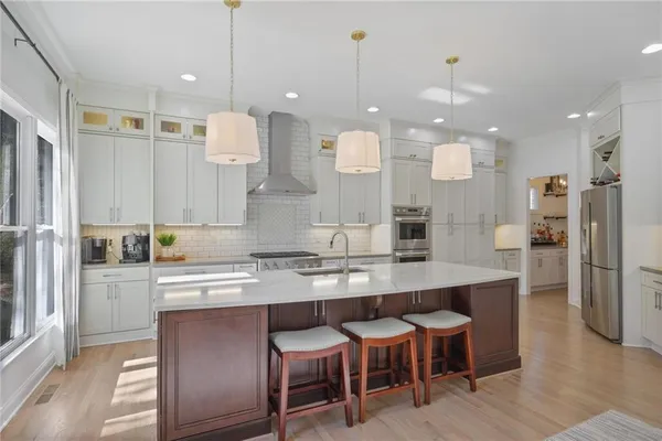 a kitchen with a dining table chairs sink and wooden floor