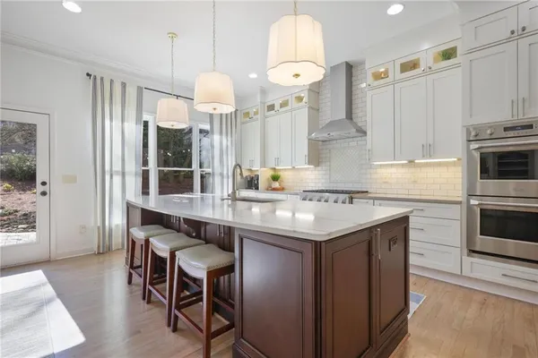 a kitchen with stainless steel appliances a table chairs and chandelier