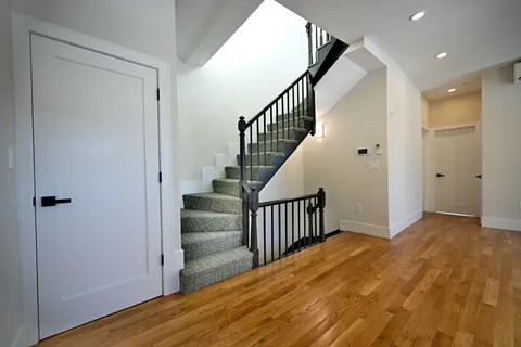 a view of hallway with wooden floor and stairs