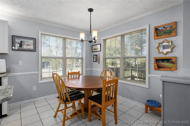a view of a dining room with furniture a chandelier and wooden floor