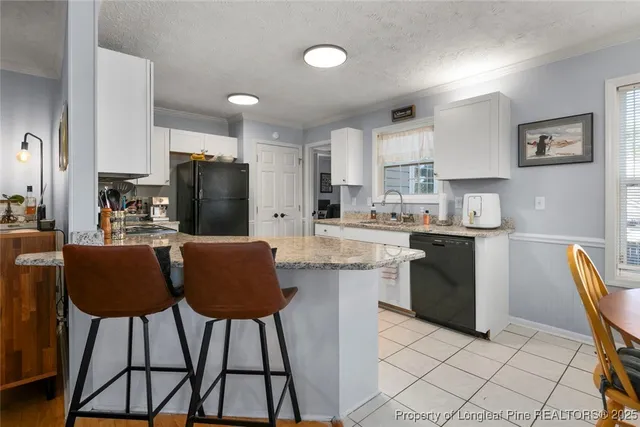 a kitchen with stainless steel appliances kitchen island granite countertop a refrigerator and a stove top oven
