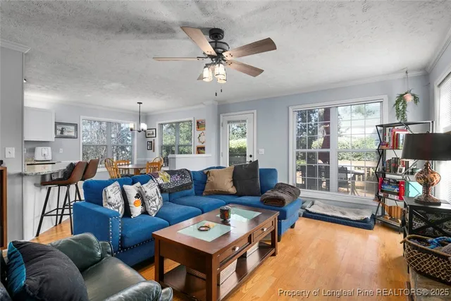 a living room with furniture a flat screen tv and a large window