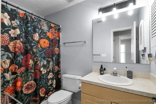 a bathroom with a sink mirror vanity and toilet