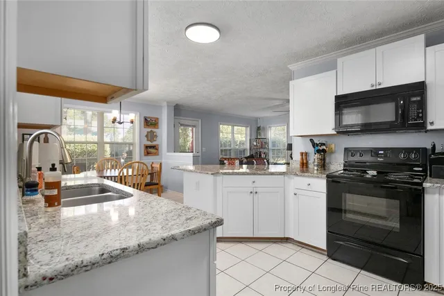 a kitchen with stainless steel appliances granite countertop a sink stove and microwave