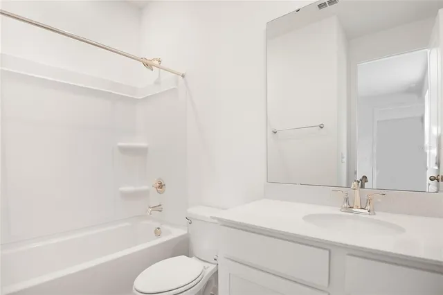 a bathroom with a granite countertop sink toilet and bathtub