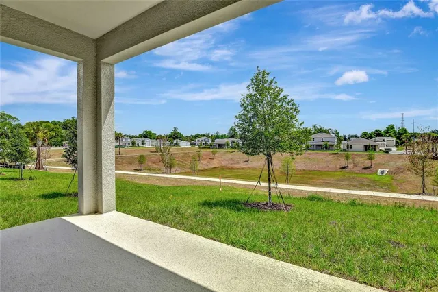 a view of a lake with a big yard and potted plants