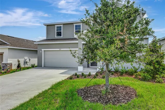 a front view of a house with a yard and garage