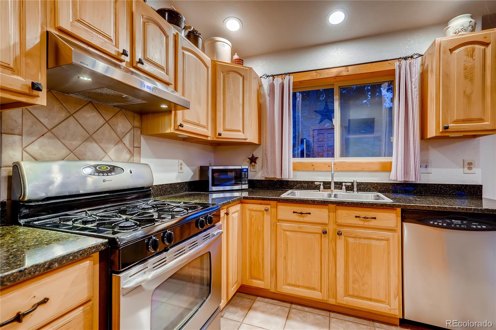 7120 County Road 43 Bailey, CO 80421 - Photo 21 of 37 a kitchen with stainless steel appliances granite countertop a stove and cabinets