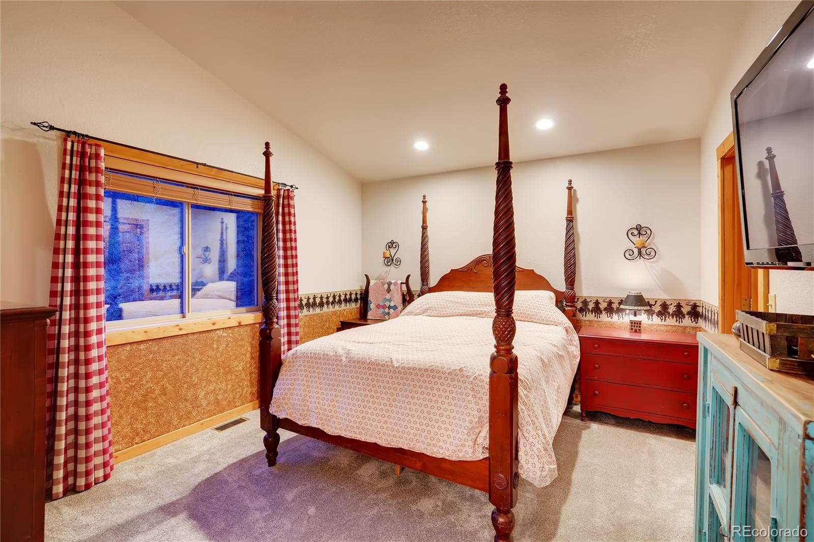 7120 County Road 43 Bailey, CO 80421 - Photo 23 of 37 a bedroom with a bed window and a flat screen tv