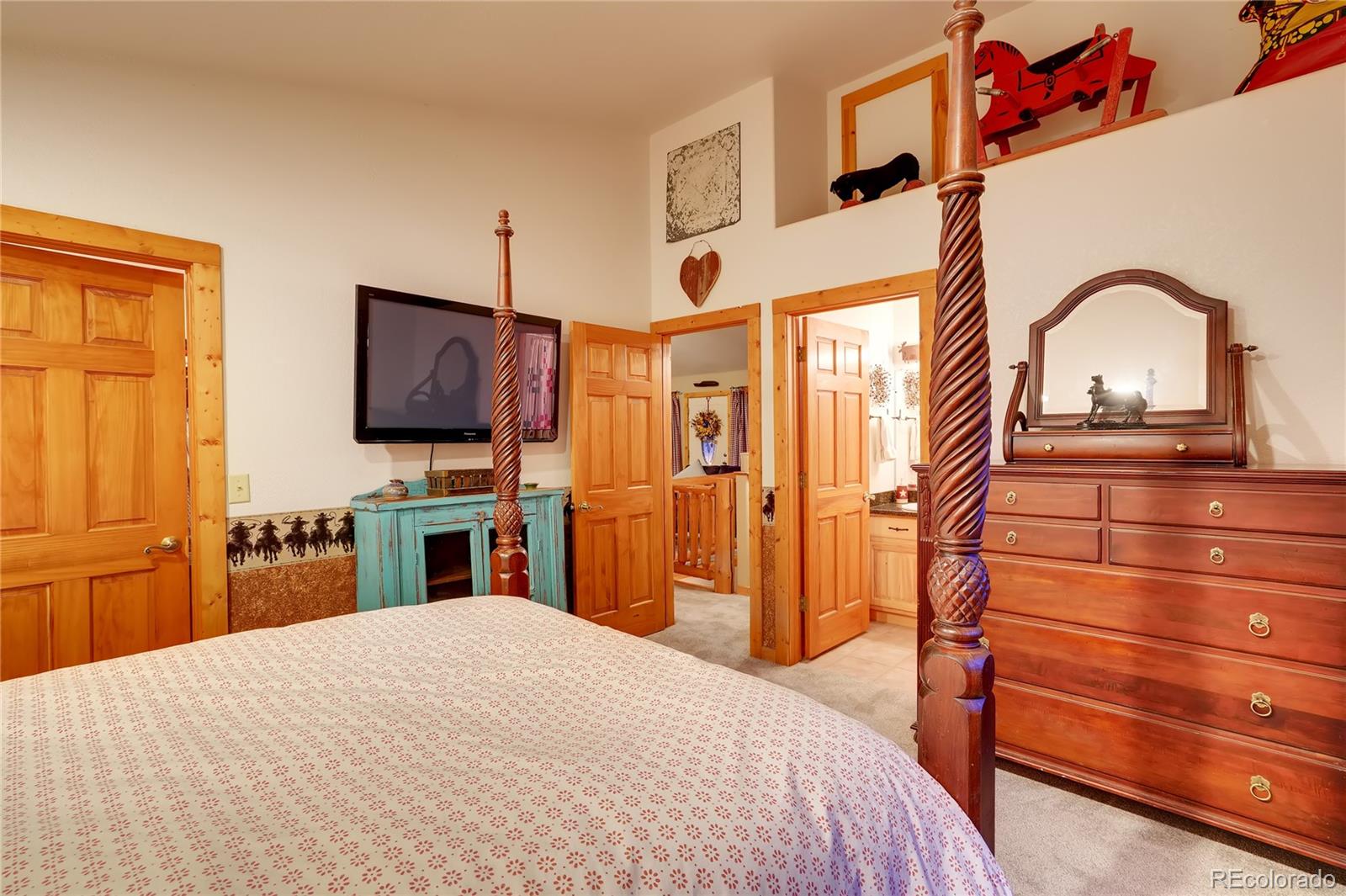 7120 County Road 43 Bailey, CO 80421 - Photo 25 of 37 a bedroom with a bed and a flat tv screen on dresser