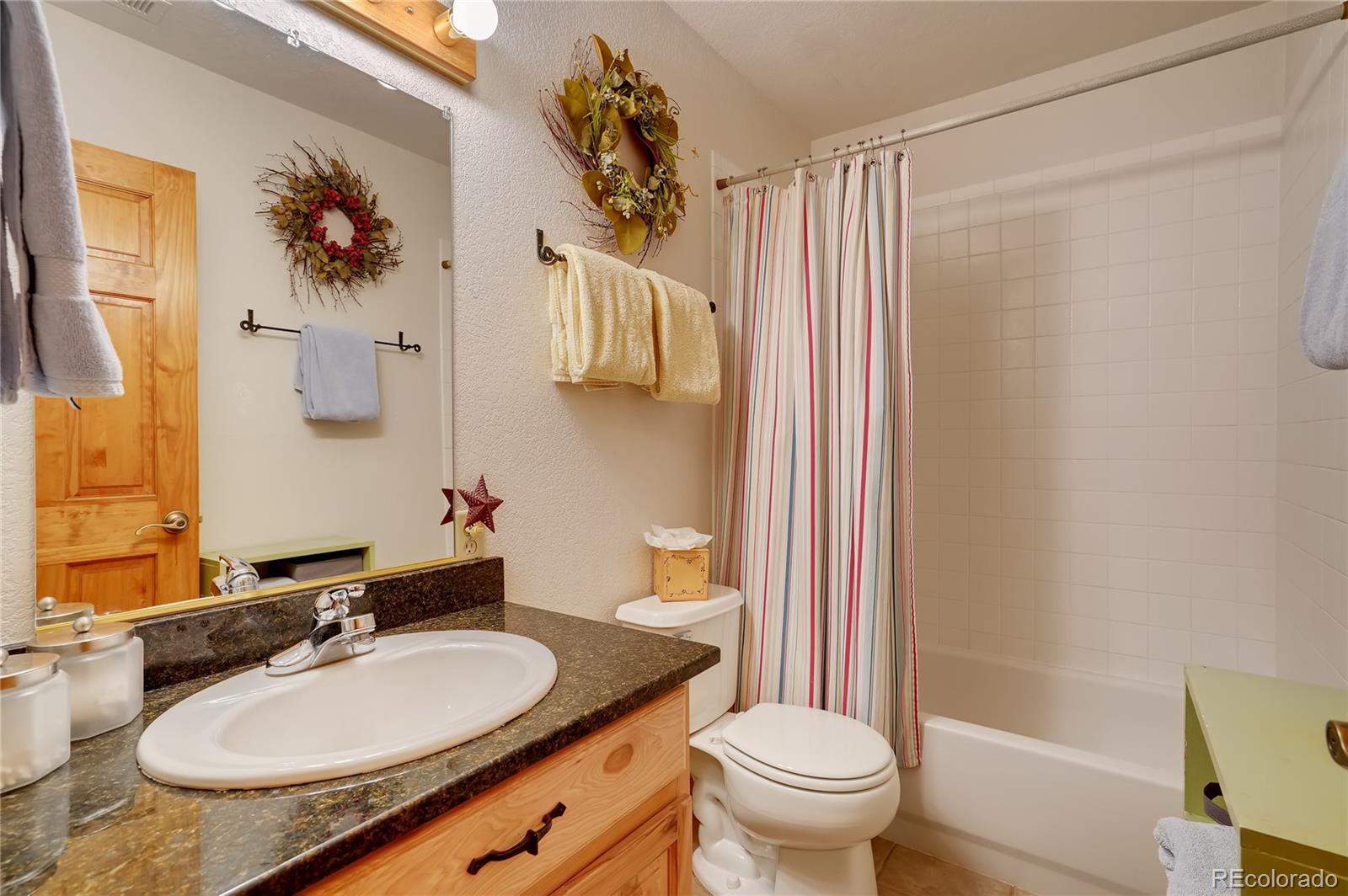 7120 County Road 43 Bailey, CO 80421 - Photo 34 of 37 a bathroom with a granite countertop sink a toilet and a mirror