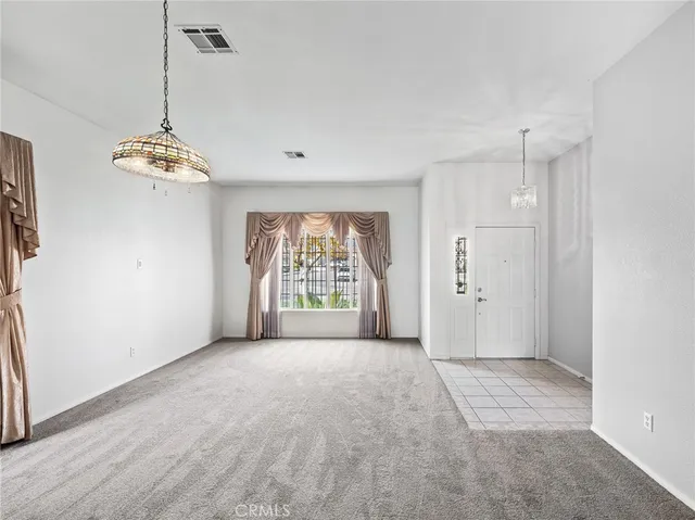 a big room with windows and chandelier fan