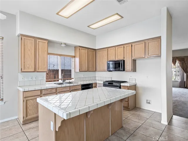 a kitchen with granite countertop a sink stove and refrigerator