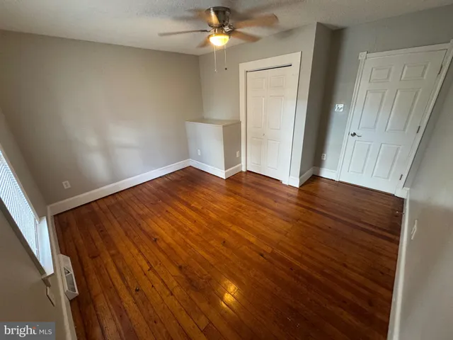 a view of empty room with wooden floor