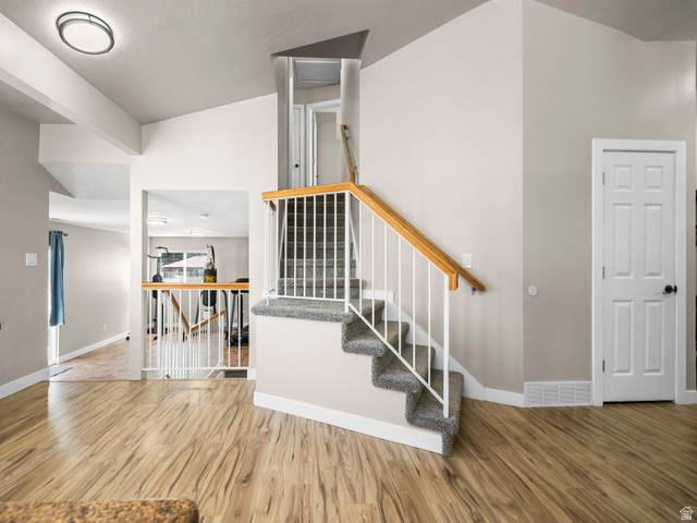 392 West Bricker Road Draper, UT 84020 - Photo 10 of 33 Light wood-finish flooring extending into various areas, complemented by a carpeted staircase with white balusters and a wood handrail