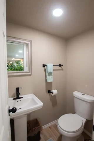 a bathroom with a sink a toilet and mirror