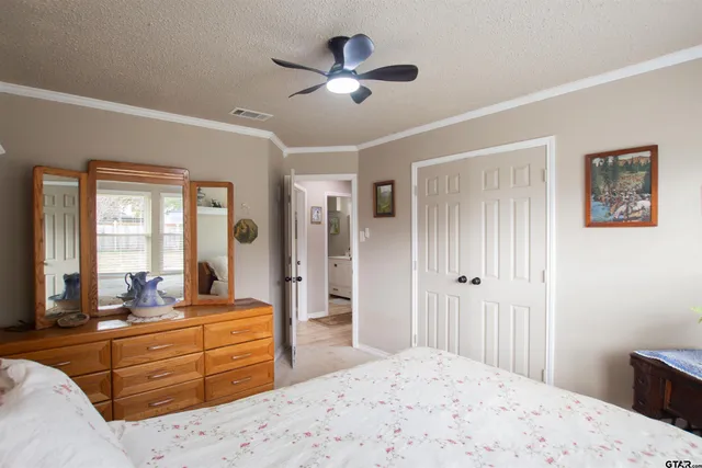 a bed room with a bed a dresser and a large mirror