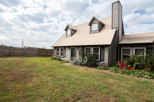 a front view of house with yard outdoor seating and barbeque oven