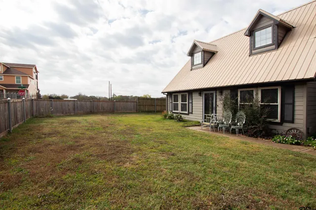 a view of a house with backyard and sitting area