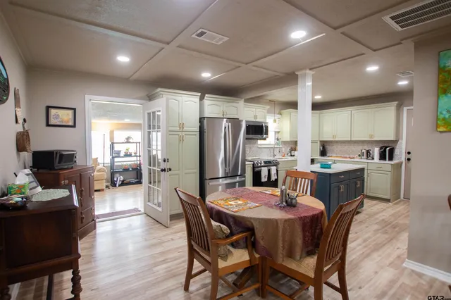 a kitchen with stainless steel appliances kitchen island granite countertop a dining table and chairs