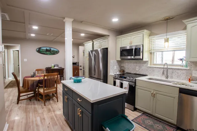 a kitchen with kitchen island a sink stove and refrigerator