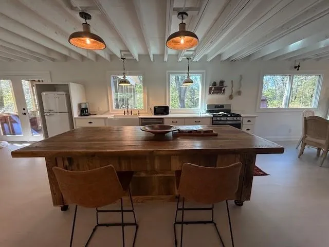 a kitchen with a dining table and chairs with wooden floor