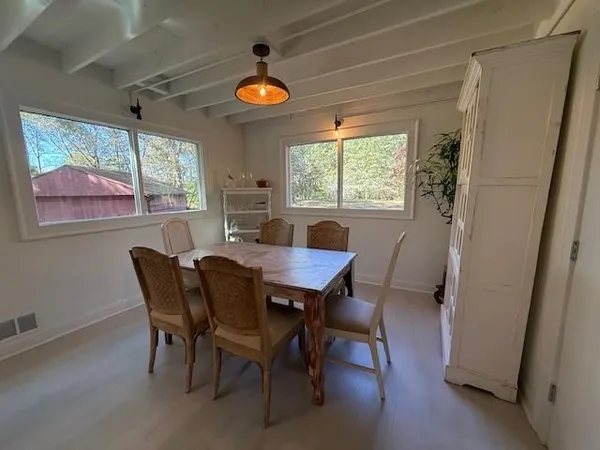 a view of a dining room with furniture a chandelier and window