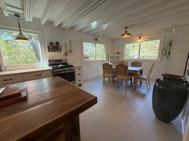 a dining room with wooden floor a chandelier a wooden table and chairs