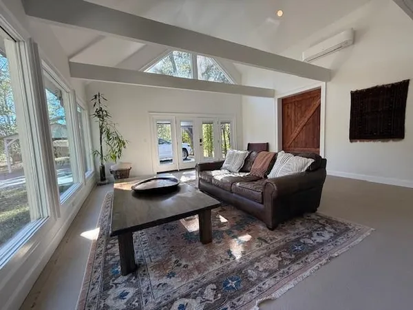 a living room with furniture a flat screen tv and a large window