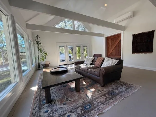 a living room with furniture a flat screen tv and a large window