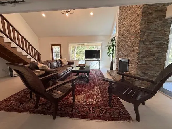 a living room with furniture a flat screen tv and a fireplace