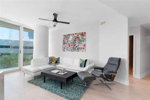 a living room with furniture a rug and a large window