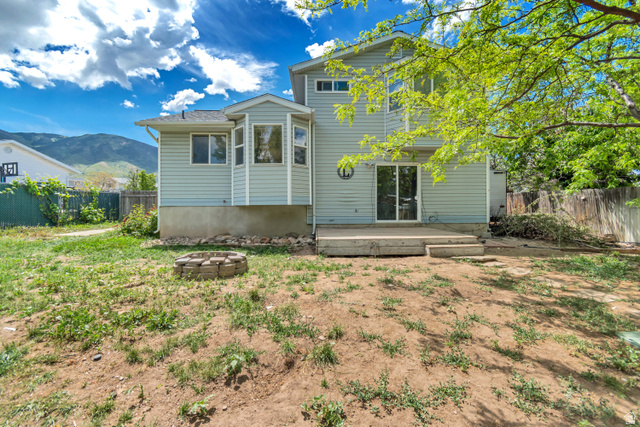 843 Deer Flat Road Tooele, UT 84074 - Photo 26 of 27 Rear exterior featuring light blue siding, a multi-pane bay window, and a glass sliding door