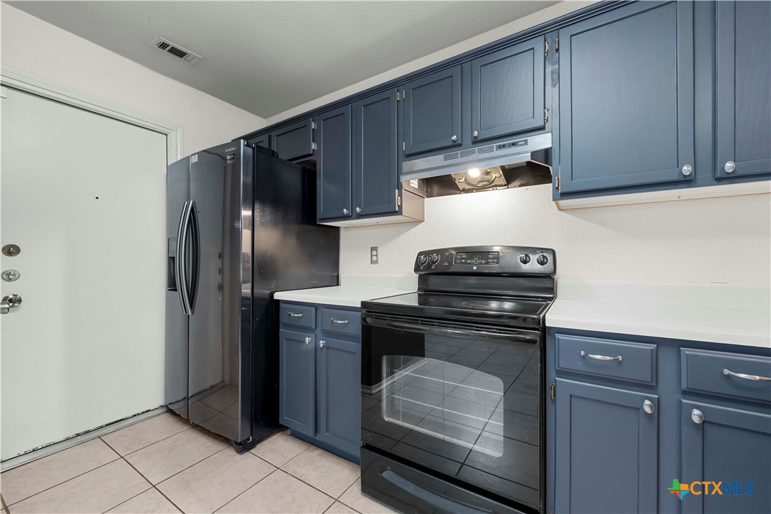 3624 Rainforest Lane Killeen, TX 76549 - Photo 24 of 27 a kitchen with granite countertop a refrigerator stove and cabinets